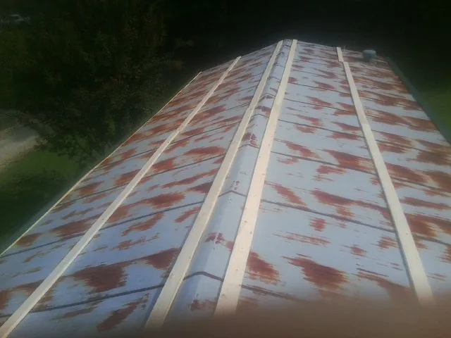 Rusted metal roof panels with new wood purlins before replacement — Storm Damage Roof Repair in Oneonta by Roofing Brothers