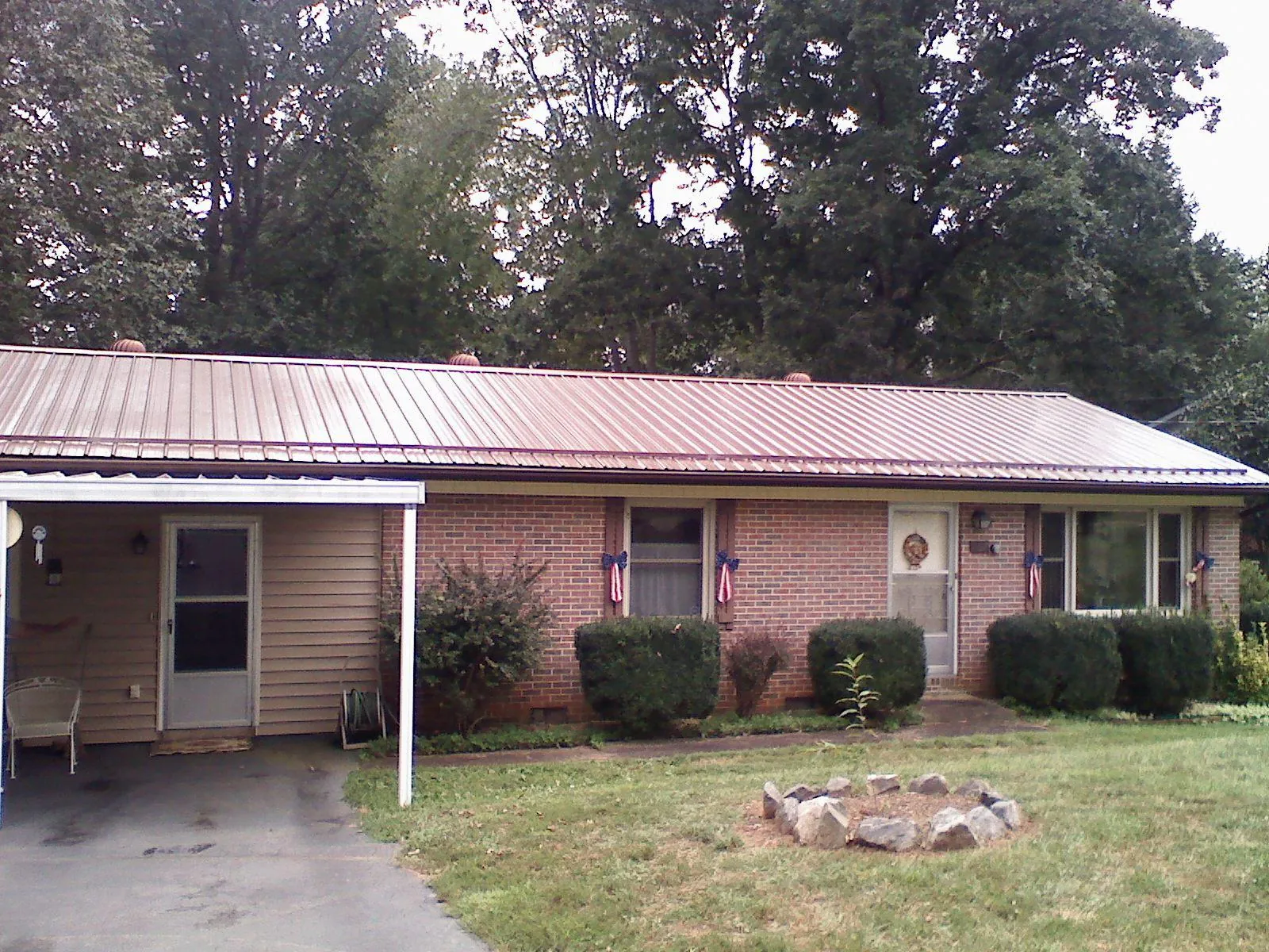Bronze metal roof and carport on a brick ranch home — Roof Repair work by our crew in Oneonta